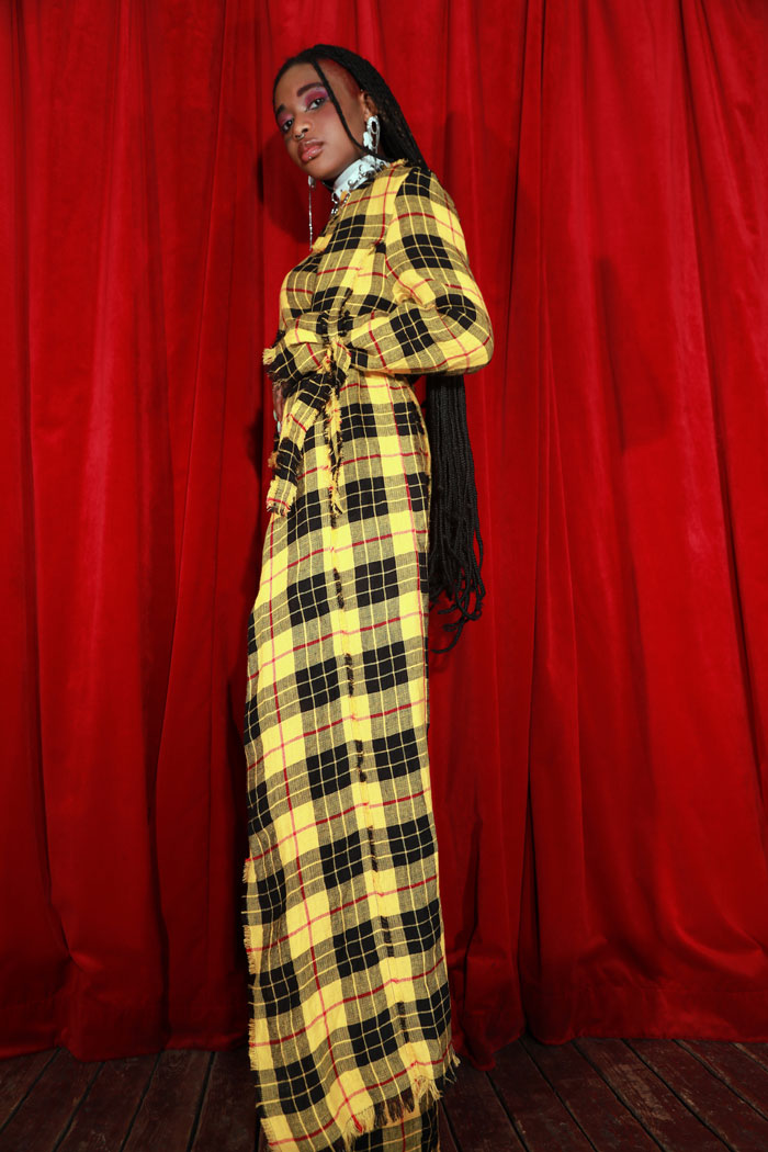 Full on tartan Trenchcoat with unique fringe details around belt. Stand out with the beautiful yellow/red vegan tartan material. The elongated length creates a beautiful shape to go with every outfit.